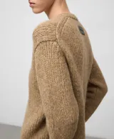 Cárdigan de punto color camel con cuello en pico, manga larga y cierre frontal de botones. Confeccionado en mezcla de alpaca y lana con acabados en canalé.