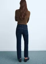 Jeans de tiro medio con diseño flare y bajo deshilachado, con cierre de cremallera y botón, trabillas y cinco bolsillos.