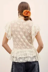 Camisa sin mangas de encaje blanco con escote en V y volados delanteros.