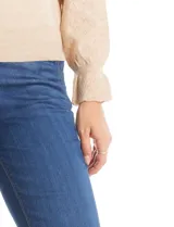 Buzo de tejido de punto gris, con cuello redondo, mangas largas con diseño de rombos calados y detalle de volado en los puños. Presenta hombros ligeramente fruncidos y terminaciones en rib acanalado.