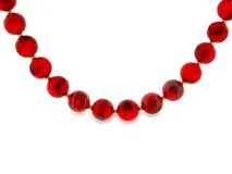 Collar de cuentas redondas rojas con vetas oscuras y pequeños detalles dorados entre cada cuenta.