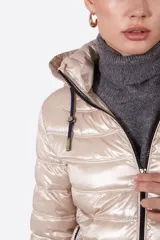 Campera puffer color beige claro, con capucha y cierre frontal.