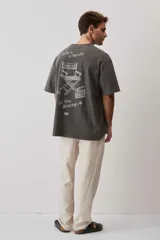 Remera marrón oversize de manga corta, con cuello redondo y pequeño estampado gráfico en el pecho.