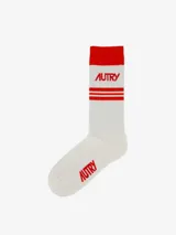 Medias deportivas blancas con detalles en rojo: puño, dos líneas horizontales y logo de la marca.