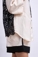 Camisa color crudo con cuello negro, mangas 3/4 y aplique de crochet negro en el frente.