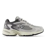 Championes urbanos New Balance modelo 725, color gris claro con detalles en gris oscuro y blanco, confeccionados en cuero y malla, con logo "N" característico en los laterales y entresuela C-CAP.