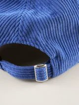 Gorra tipo baseball confeccionada en pana color azul marino, con parche rectangular lateral que incluye el logo de la marca Benson & Thomas.