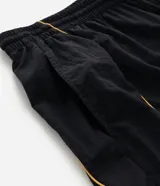 Pantalón deportivo de microfibra color negro, con corte holgado y diseño de piping contrastante en color amarillo. Cuenta con cintura elástica con cordón de ajuste, bolsillos laterales y logo bordado.