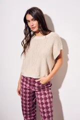 Chaleco de punto con textura acanalada y acabado brillante, de corte holgado, cuello redondo y mangas cortas estilo sisa.