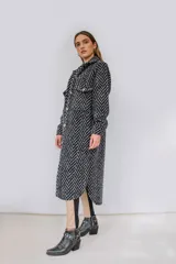 Tapado largo estilo chemise confeccionado en lana italiana tejida con patrón de espiga en color negro y gris. Presenta cierre frontal con botones y bolsillos con solapa.