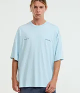 Remera celeste de corte oversized con cuello redondo y mangas cortas. Cuenta con estampa lettering frontal con las frases "Shaped by Time" y "Standard Supply".