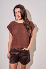 Chaleco oversize de punto texturado color rosa, con escote redondo y mangas sisa caídas.
