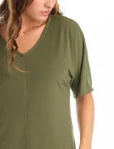 Blusa de silueta fluida con escote en V, manga japonesa corta y costura central vertical en el frente. Confeccionada en tejido de punto con acabado mate, presenta un diseño con largo asimétrico, siendo más larga en la espalda.
