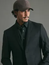 Saco sport de corte clásico, con cuello de solapa, cierre frontal de dos botones y bolsillos de ribete laterales.