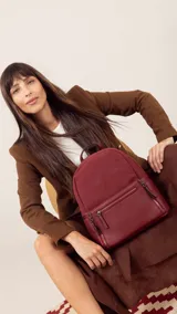 Mochila color bordó combinada con nobuck, con bolsillo delantero con broche y cierre, bolsillos laterales, asas regulables y bolsillos internos.