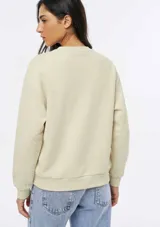Buzo de cuello redondo y manga larga, confeccionado en tejido de punto fino con diseño liso y corte holgado.