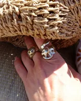 Anillo de diseño orgánico con forma irregular que evoca texturas marinas, con estructura abierta y acabado brillante.