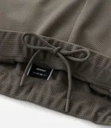 Pantalón deportivo de corte ajustado, confeccionado en tejido de poliéster texturizado color negro. Presenta cintura elástica con cordón de ajuste, bolsillos laterales con cierre y puños elásticos en los tobillos.
