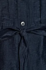 Chaleco azul marino confeccionado en hilatura con lino, con cuello solapa, manga sisa y trabillas en los hombros. Cuenta con bolsillos de plastrón con solapa en el delantero, cinturón ajustable del mismo tejido y bajo asimétrico con aberturas laterales. Cierre frontal con botones.