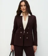 Blazer femenino de sastrería confeccionado en tejido Punto Roma, con cuello solapa, cierre frontal con ganchos y botones decorativos dorados con escudo grabado.