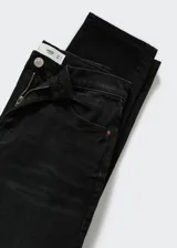 Jeans mom-fit de tiro alto color negro, confeccionados en mezcla de algodón y elastano con diseño de cinco bolsillos, trabillas y cierre frontal de cremallera y botón.