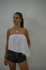 Top strapless de corte holgado y asimétrico, confeccionado en tela liviana de color blanco.