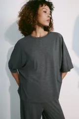 Remera oversize gris melange de tejido fluido, con cuello redondo y mangas cortas amplias.