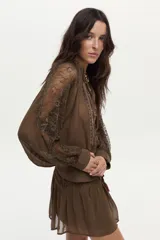 Blusa verde oliva vaporosa con mangas abullonadas y encaje transparente, con bordado floral artesanal y detalles de canutillos.