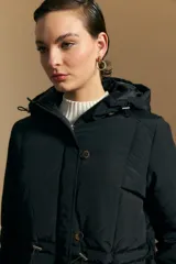 Campera acolchada de nylon color negro, con capucha ajustable, cierre frontal y botones. Diseño capitoneado con ajuste en la cintura.