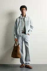 Jeans de corte recto color celeste claro, con tiro medio, diseño de cinco bolsillos, efecto lavado y bajo con acabado irregular deshilachado.