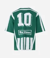 Remera de punto manga corta con diseño rayado vertical en color verde y blanco. Presenta cuello redondo, sisa desplazada y detalles gráficos tipo jersey de fútbol con el número 10 y el logo de la marca Reckless en el frente.
