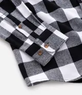 Camisa de franela marca Blue Steel, con diseño de cuadros grandes en blanco y negro, cuello inglés, manga larga y cierre frontal con botones.