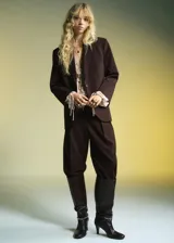 Pantalón de tiro medio color marrón, con diseño wide leg, pinzas en la parte delantera, bolsillos laterales y cierre frontal con botón, gancho y cremallera.