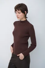 Polera de tejido morley color azul, con cuello alto y mangas largas, de corte ajustado al cuerpo.