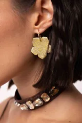 Aro colgante con argolla de acero quirúrgico y dije en forma de flor con acabado brillante y texturizado. Pieza artesanal pintada a mano.