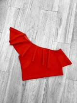 Top corto con un solo hombro y volado grande.