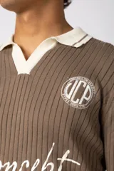 Sweater de punto acanalado en color negro, con cuello polo en contraste color crema. Presenta detalles bordados en el pecho y estampado tipográfico central con la frase 'Concept ALL GOOD FEELS'.