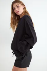 Chaqueta bomber rústica color negro con cuello redondo y cierre frontal de metal.
