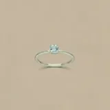 Anillo de plata 925 con piedra topacio celeste de corte rectangular engarzada en seis puntas y diseño fino.