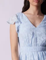 Vestido midi celeste de gasa estampada, marca Julia Jordan. Tiene escote en V, mangas cortas con volados y forro interno a tono.