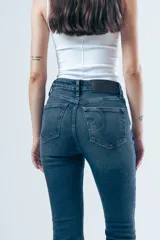 Jeans oxford de tiro alto, color azul oscuro, con diseño ajustado en las piernas y leve ensanchamiento en la parte inferior.