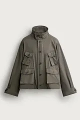 Cazadora relaxed fit de tejido con mezcla de algodón en color verde militar. Cuenta con cuello subido, manga larga con puño ajustable, múltiples bolsillos frontales de plastrón con solapa y cierre frontal con botones.