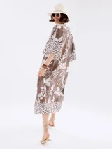 Vestido marrón con estampado floral blanco y detalles animal print en ruedo y mangas.