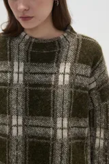 Sweater de punto jacquard con diseño a cuadros en tonos beige y bordó, de corte holgado, cuello redondo y mangas largas.