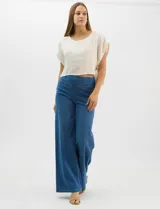 Jegging de denim azul oscuro con silueta estilo palazzo, tiro alto y pierna amplia, con pretina ancha elástica y sin bolsillos frontales.