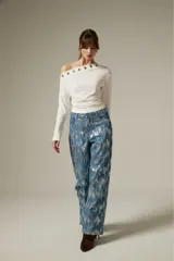 Pantalon de jean recto con acabado brillante de lentejuelas plateadas sobre base azul, de tiro medio.