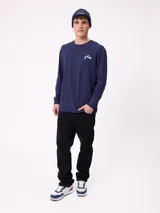 Remera de manga larga color negro con estampado gráfico blanco en la espalda, perteneciente a la marca Rusty.