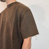 Remera de corte oversize en color verde oliva con efecto lavado, confeccionada en tela rústica pesada, con cuello redondo y bordes sin costura.