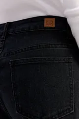 Jean wide leg de tiro medio en color negro, con diseño de corte amplio y detalle de tachas metálicas a lo largo de los laterales y en los bolsillos delanteros.