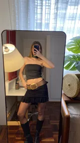 Minifalda negra de lino con spandex, tiro bajo y detalle de volados en el ruedo.